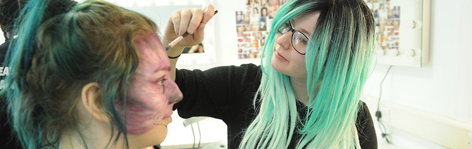 student applying make up to a model